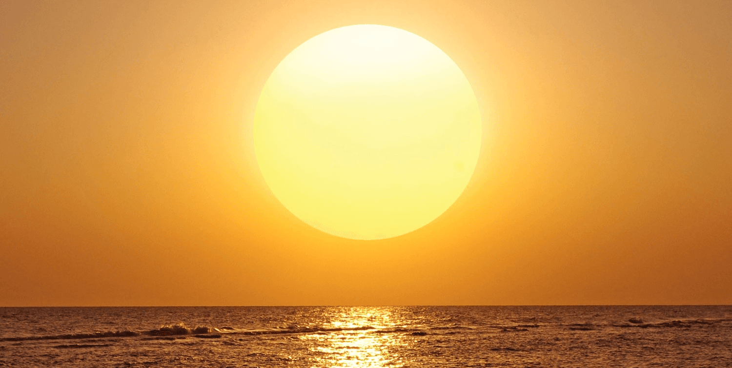The sun setting over a distant horizon